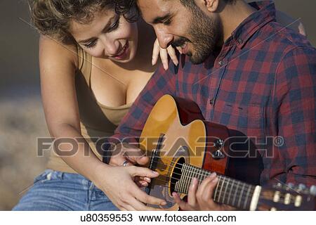 Young couple, man playing guitar View Large Photo Image Stock Image - Young couple, man playing guitar. Fotosearch
