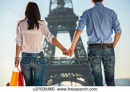 Young couple strolling in front of Eiffel Tower, Paris, France View Large Photo Image Stock Image - Young couple strolling in front of Eiffel Tower, Paris, France. Fotosearch