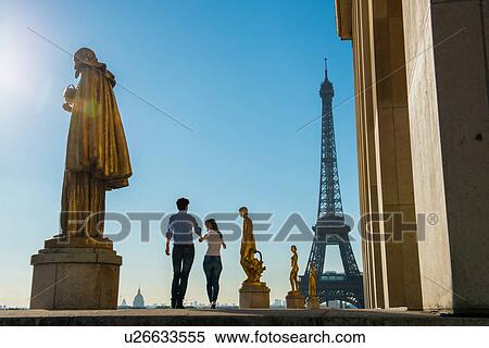 Young couple strolling near Eiffel Tower, Paris, France View Large Photo Image Stock Photography - Young couple strolling near Eiffel Tower, Paris, France. Fotosearch