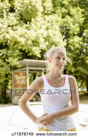 Stock Photo - Young female basketball player taking a break in park. Fotosearch