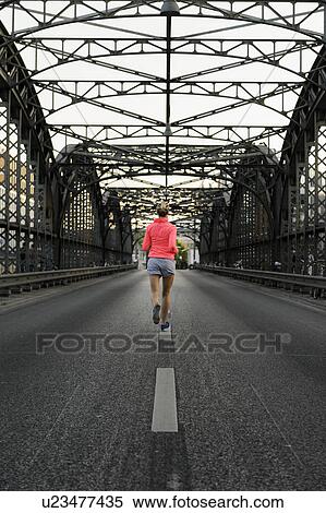 Young female runner crossing bridge View Large Photo Image Stock Photography - Young female runner crossing bridge. Fotosearch