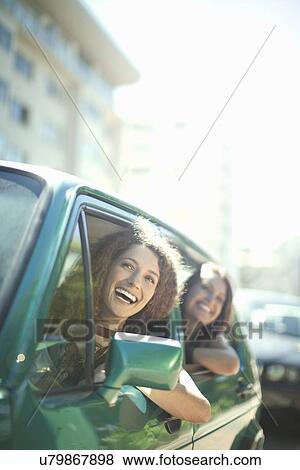 Stock Photo - Young females leaning out of car window. Fotosearch