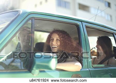 Picture - Young friends enjoying road trip in car. Fotosearch