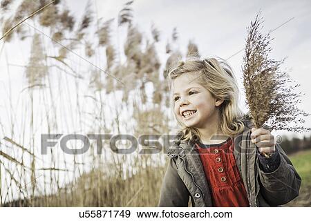 Stock Photo - Young girl collecting marsh grasses. Fotosearch