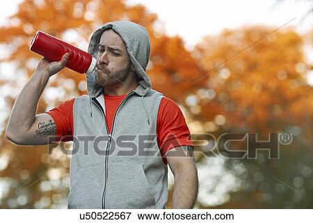 Young man drinking from plastic bottle View Large Photo Image Stock Photo - Young man drinking from plastic bottle. Fotosearch
