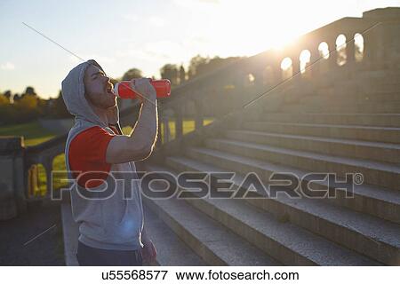 Stock Photo - Young man drinking from plastic bottle. Fotosearch