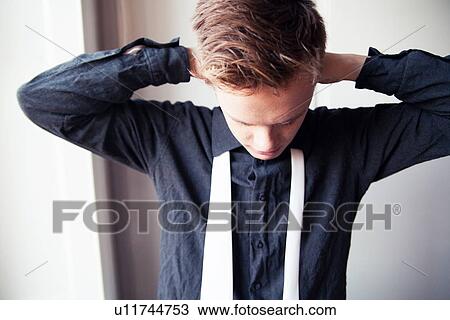 Young man getting dressed in shirt and tie View Large Photo Image Stock Image - Young man getting dressed in shirt and tie. Fotosearch