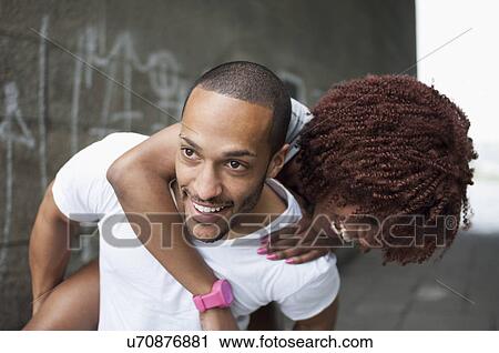 Young man giving woman piggyback View Large Photo Image Stock Image - Young man giving woman piggyback. Fotosearch
