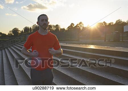 Young man jogging on steps View Large Photo Image Stock Photo - Young man jogging on steps. Fotosearch