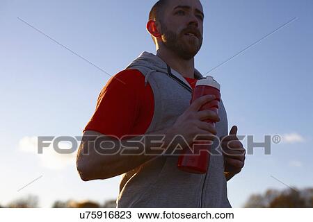 Young man jogging with plastic bottle View Large Photo Image Stock Image - Young man jogging with plastic bottle. Fotosearch