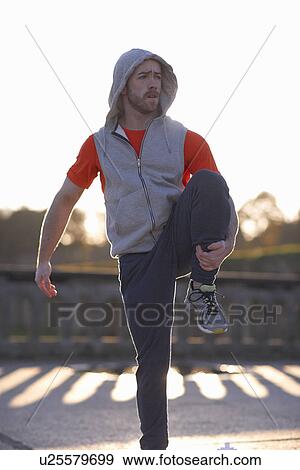 Young man on one leg stretching View Large Photo Image Stock Photo - Young man on one leg stretching. Fotosearch