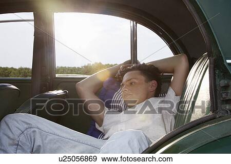 Young man posing in back seat of vintage morris minor View Large Photo Image Stock Photo - Young man posing in back seat of vintage morris minor. Fotosearch