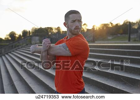 Young man stretching arm View Large Photo Image Stock Image - Young man stretching arm. Fotosearch