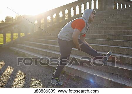 Young man stretching leg on step View Large Photo Image Stock Photo - Young man stretching leg on step. Fotosearch