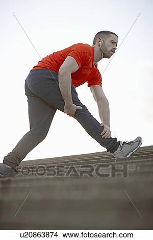 Young man stretching leg on steps View Large Photo Image Picture - Young man stretching leg on steps. Fotosearch