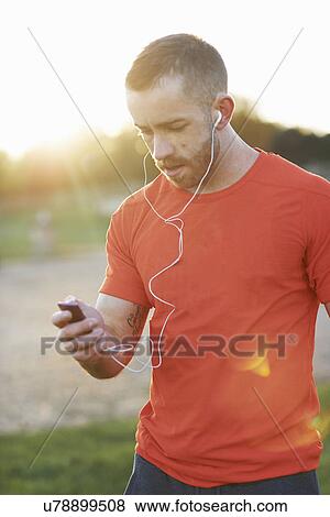 Young man using mp3 player View Large Photo Image Stock Photo - Young man using mp3 player. Fotosearch