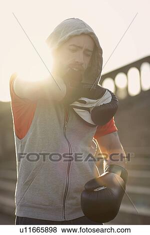 Young man wearing boxing gloves View Large Photo Image Stock Photo - Young man wearing boxing gloves. Fotosearch