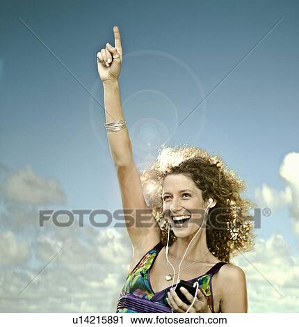 Young woman listening to MP3 player dancing outdoors View Large Photo Image Stock Image - Young woman listening to MP3 player dancing outdoors. Fotosearch