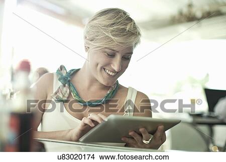 Young woman using digital tablet in cafe bar View Large Photo Image Picture - Young woman using digital tablet in cafe bar. Fotosearch