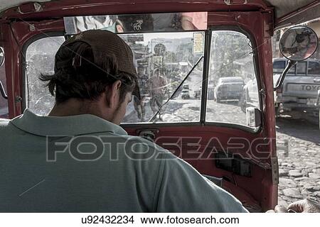 Picture - Auto rickshaw driver on street, Barrio El Centro, Copan, Copan Ruinas, Honduras. Fotosearch