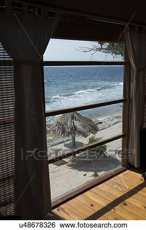 Beach viewed through from a window of a resort, Utopia Village, Utila Island, Bay Islands, Honduras View Large Photo Image Stock Photograph - Beach viewed through from a window of a resort, Utopia Village, Utila Island, Bay Islands, Honduras. Fotosearch