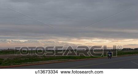 Biker on road with mountains in the background, Atlas Mountains, Marrakesh, Morocco View Large Photo Image Picture - Biker on road with mountains in the background, Atlas Mountains, Marrakesh, Morocco. Fotosearch