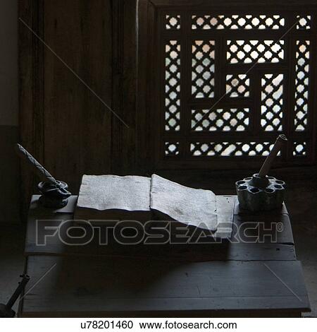 Stock Image - Close-up of an old book with ink well on table at Ben Youssef Madrasa, Medina, Marrakesh, Morocco. Fotosearch