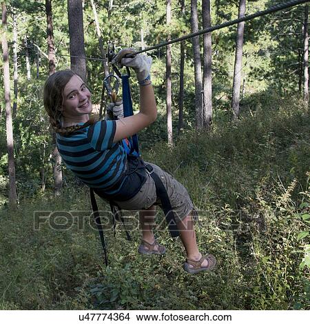 Picture - Girl riding a zip line in a forest, Copan, Copan Ruinas, Copan Department, Honduras. Fotosearch