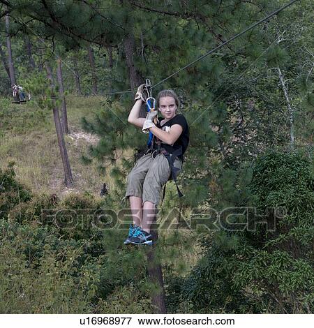 Stock Photo - Girl riding a zip line in a forest, Copan, Copan Ruinas, Copan Department, Honduras. Fotosearch