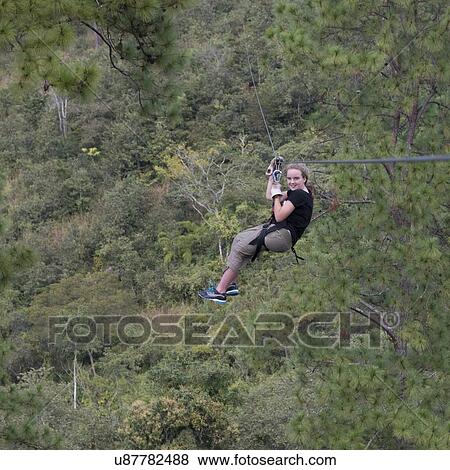 Girl riding a zip line in a forest, Copan, Copan Ruinas, Copan Department, Honduras View Large Photo Image Stock Photo - Girl riding a zip line in a forest, Copan, Copan Ruinas, Copan Department, Honduras. Fotosearch