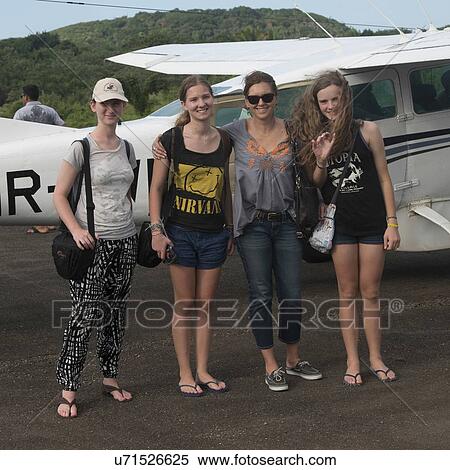 Stock Photography - Group of Women standing in front of a seaplane and smiling, Utila Town, Utila Island, Bay Islands, Honduras. Fotosearch