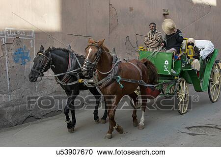 Stock Image - Horsedrawn moving on the street, Marrakesh, Morocco. Fotosearch