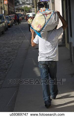 Man carrying sack on shoulder on street, Barrio El Centro, Copan, Copan Ruinas, Honduras View Large Photo Image Stock Photo - Man carrying sack on shoulder on street, Barrio El Centro, Copan, Copan Ruinas, Honduras. Fotosearch