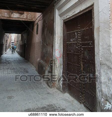 Stock Image - People on a narrow street, Medina, Marrakesh, Morocco. Fotosearch