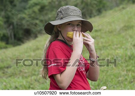 Portrait of a girl eating fruit, Finca El Cisne, Honduras View Large Photo Image Stock Image - Portrait of a girl eating fruit, Finca El Cisne, Honduras. Fotosearch