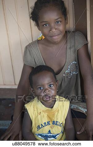 Portrait of a girl sitting with her brother, Cayman Cay, Utila Island, Bay Islands, Honduras View Large Photo Image Stock Photo - Portrait of a girl sitting with her brother, Cayman Cay, Utila Island, Bay Islands, Honduras. Fotosearch