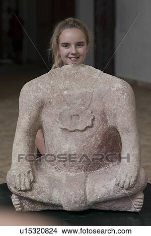 Picture - Portrait of a teenage girl with Mayan headless clay statue, Copan, Copan Ruinas, Honduras. Fotosearch