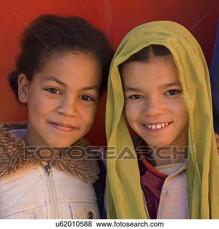Stock Photo - Portrait of two girls smiling, Kasbah Azul, Agdz, Morocco. Fotosearch