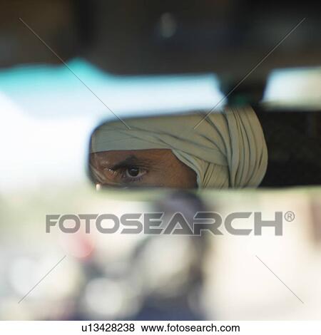 Stock Photo - Reflection of a Tuareg man in the rear-view mirror, Atlas Mountains, Morocco. Fotosearch
