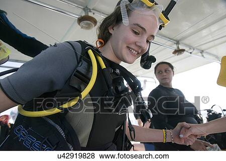 Stock Photo - Scuba diver preparing to dive from tourboat, Utila, Bay Islands, Honduras. Fotosearch
