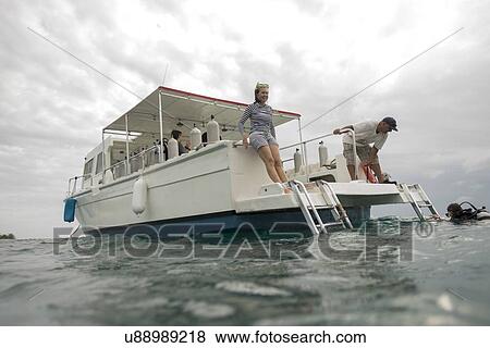 Stock Photo - Scuba diver return back to the tourboat, Utila, Bay Islands, Honduras. Fotosearch
