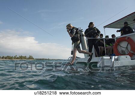 Scuba divers diving from tourboat into the sea, Utila, Bay Islands, Honduras View Large Photo Image Stock Photo - Scuba divers diving from tourboat into the sea, Utila, Bay Islands, Honduras. Fotosearch