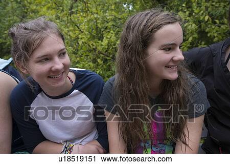 Stock Image - Two teenage girls sitting together and smiling, Utila, Bay Islands, Honduras. Fotosearch