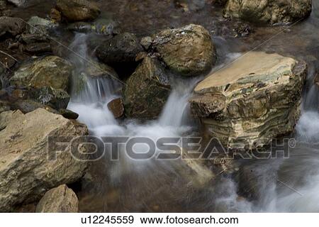 Water flowing through rocks, Macaw Mountain Bird Park, Copan, Copan Ruinas, Copan Department, Honduras View Large Photo Image Stock Photo - Water flowing through rocks, Macaw Mountain Bird Park, Copan, Copan Ruinas, Copan Department, Honduras. Fotosearch