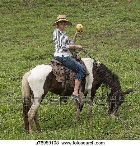 Stock Photo - Woman horseback riding in a field, Finca El Cisne, Honduras. Fotosearch