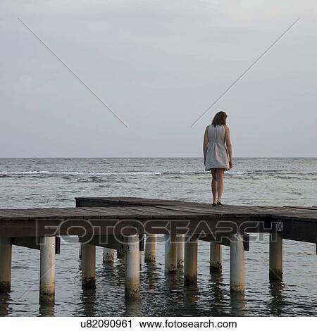 Woman standing on a pier and looking at sea, Utila Island, Bay Islands, Honduras View Large Photo Image Stock Image - Woman standing on a pier and looking at sea, Utila Island, Bay Islands, Honduras. Fotosearch