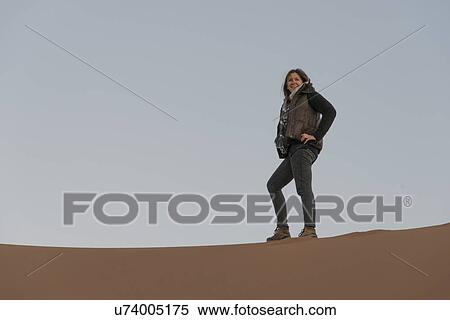 Stock Photography - Woman standing on Erg Chegaga Dunes, Sahara Desert, Souss-Massa-Draa, Morocco. Fotosearch