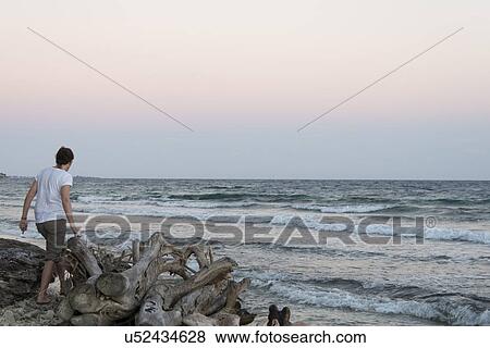 Stock Photo - Woman standing on the beach, Bay Islands, Honduras. Fotosearch