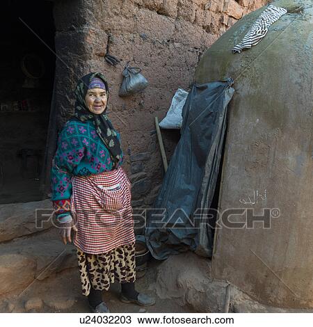 Stock Image - Woman standing outside her house, Morocco. Fotosearch