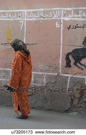 Stock Image - Woman walking on a street, Medina, Marrakesh, Morocco. Fotosearch